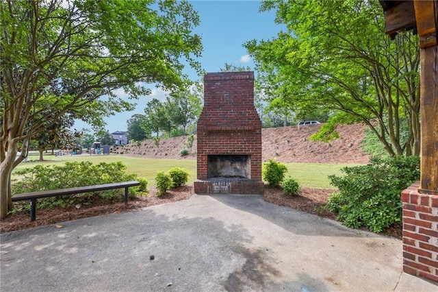 view of patio featuring an outdoor brick fireplace