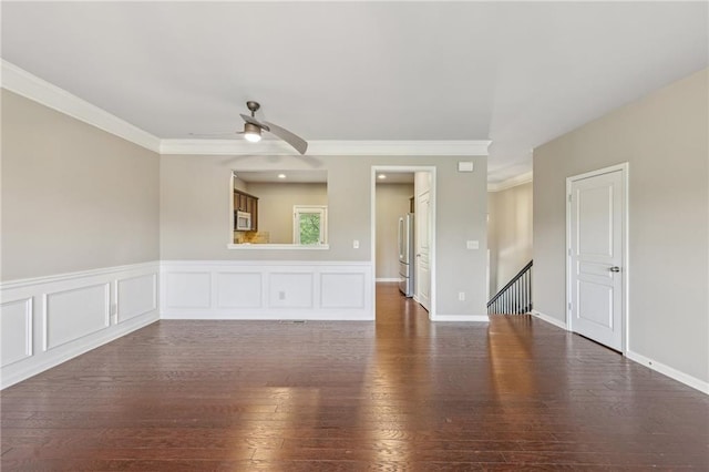 spare room featuring ornamental molding, dark wood-type flooring, and a ceiling fan