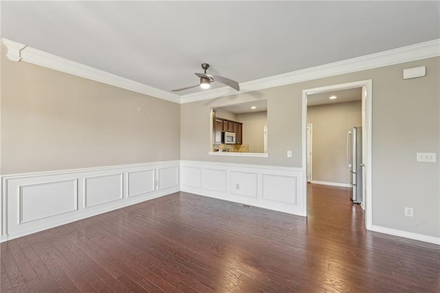 empty room with ornamental molding, dark wood-style floors, and a ceiling fan