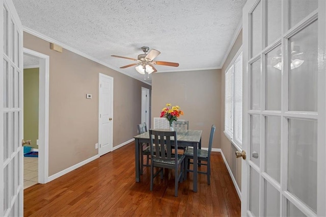 dining room featuring french doors, a textured ceiling, ceiling fan, crown molding, and hardwood / wood-style flooring