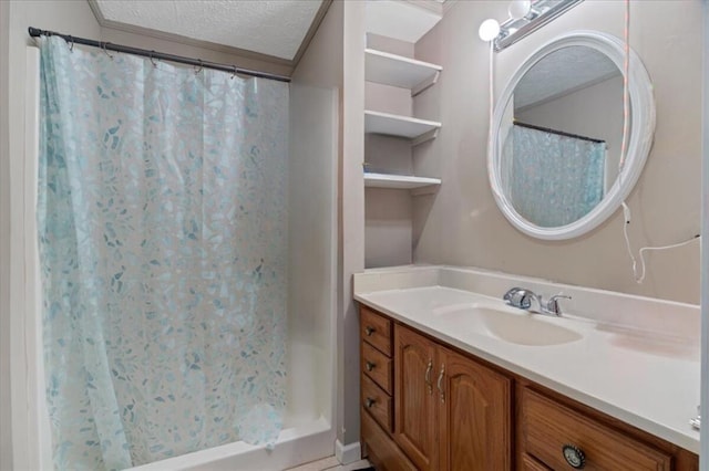 bathroom with crown molding, vanity, a textured ceiling, and walk in shower