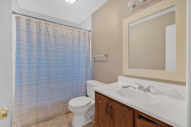 bathroom featuring curtained shower, vanity, a textured ceiling, and toilet