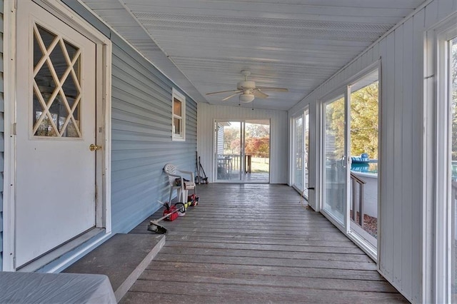 unfurnished sunroom with ceiling fan