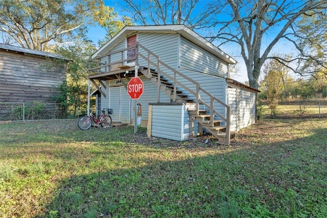 rear view of property featuring a wooden deck and a lawn