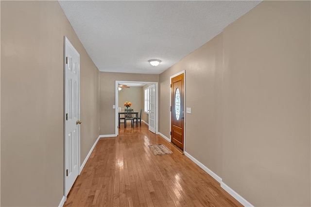 interior space with a textured ceiling and light hardwood / wood-style floors