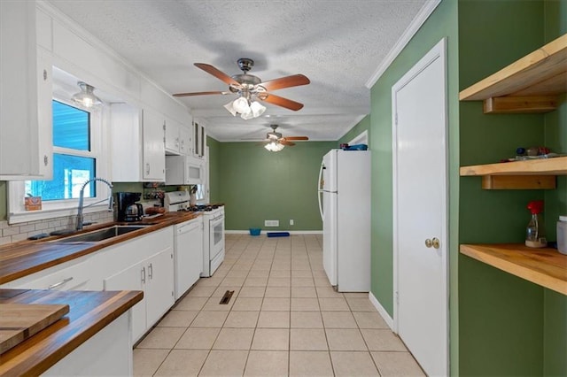 kitchen featuring white cabinets, white appliances, light tile patterned flooring, and sink