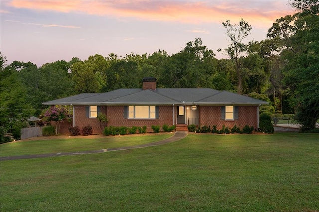 ranch-style home with a yard