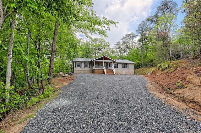 manufactured / mobile home featuring covered porch and gravel driveway