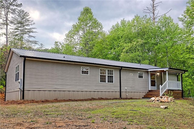 rear view of house with covered porch and metal roof