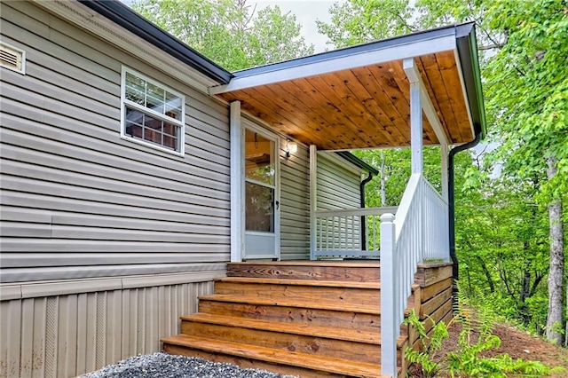 view of exterior entry featuring covered porch