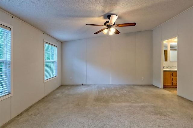 empty room with a textured ceiling, light carpet, and ceiling fan