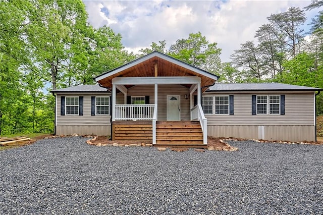 manufactured / mobile home with covered porch and gravel driveway