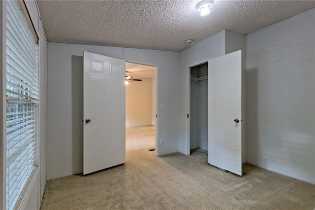 unfurnished bedroom with carpet, a textured ceiling, and a closet