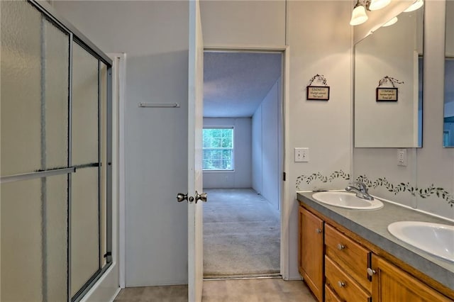 full bath featuring a shower with door and double vanity