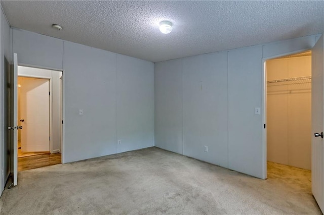 carpeted spare room with a textured ceiling and a smoke detector
