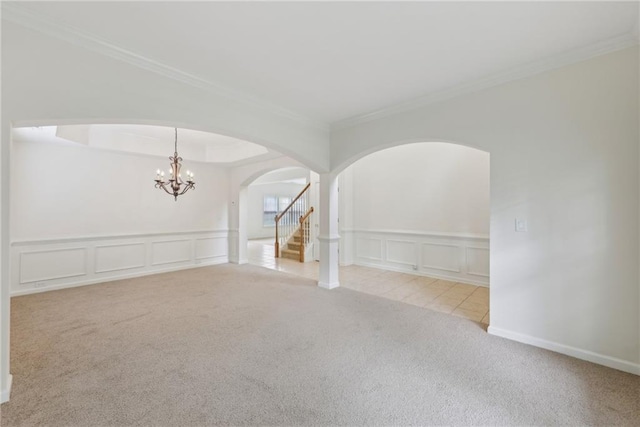 230 Collins View Ct, Lawrenceville, GA 30043 - spare room featuring a decorative wall, arched walkways, carpet floors, a chandelier, and crown molding