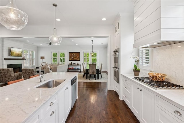 5971 Brundage Ln, Norcross, GA 30071 - kitchen featuring a sink, appliances with stainless steel finishes, premium range hood, open floor plan, and a fireplace