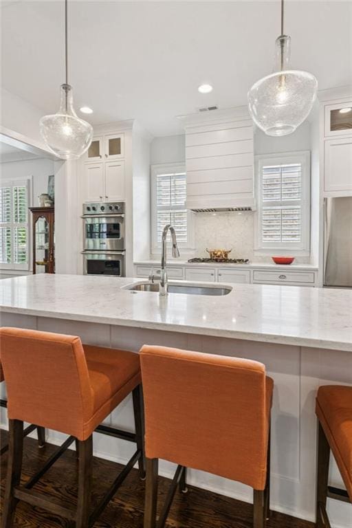 5971 Brundage Ln, Norcross, GA 30071 - kitchen with stainless steel appliances, a sink, light stone countertops, glass insert cabinets, and recessed lighting