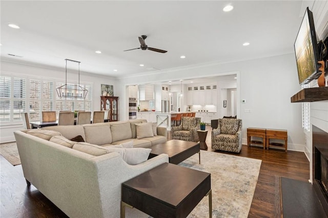 5971 Brundage Ln, Norcross, GA 30071 - living area with a fireplace with flush hearth, crown molding, plenty of natural light, a ceiling fan, and dark wood-style floors