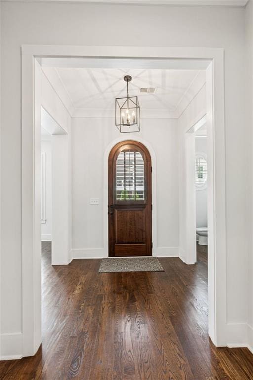 5971 Brundage Ln, Norcross, GA 30071 - entrance foyer with dark wood-style floors, a chandelier, crown molding, baseboards, and arched walkways