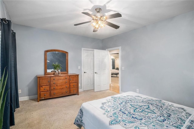 bedroom featuring baseboards, light colored carpet, and ceiling fan