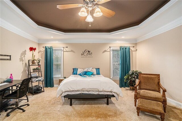 bedroom with a tray ceiling, ceiling fan, ornamental molding, and light colored carpet