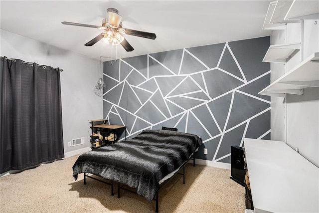 bedroom with visible vents, a ceiling fan, an accent wall, and baseboards