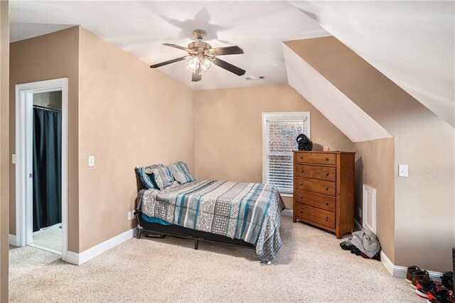 bedroom featuring light colored carpet, vaulted ceiling, and ceiling fan