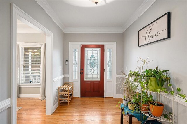 dining room with light wood-type flooring, crown molding, and a notable chandelier