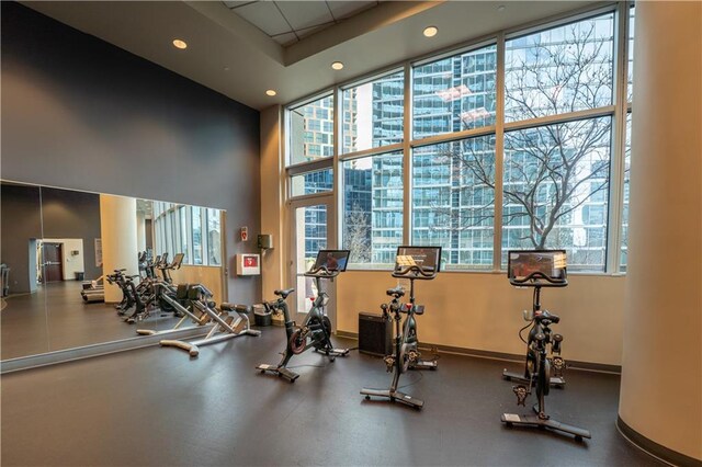workout area with a towering ceiling, baseboards, and recessed lighting