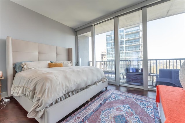 bedroom featuring a wall of windows, access to exterior, and wood finished floors