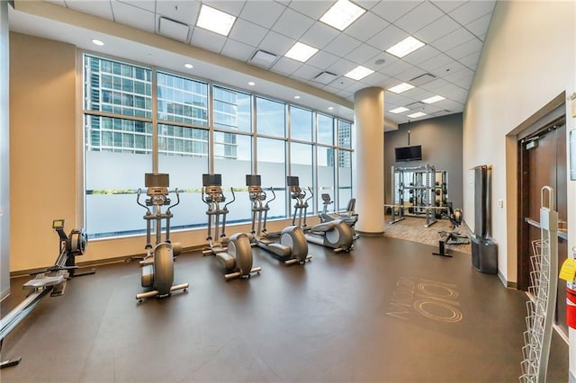 exercise room with a high ceiling, visible vents, and a drop ceiling