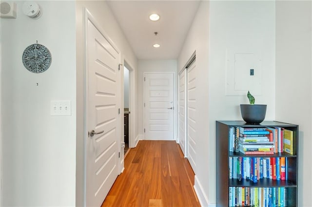 hallway with electric panel, recessed lighting, and wood finished floors