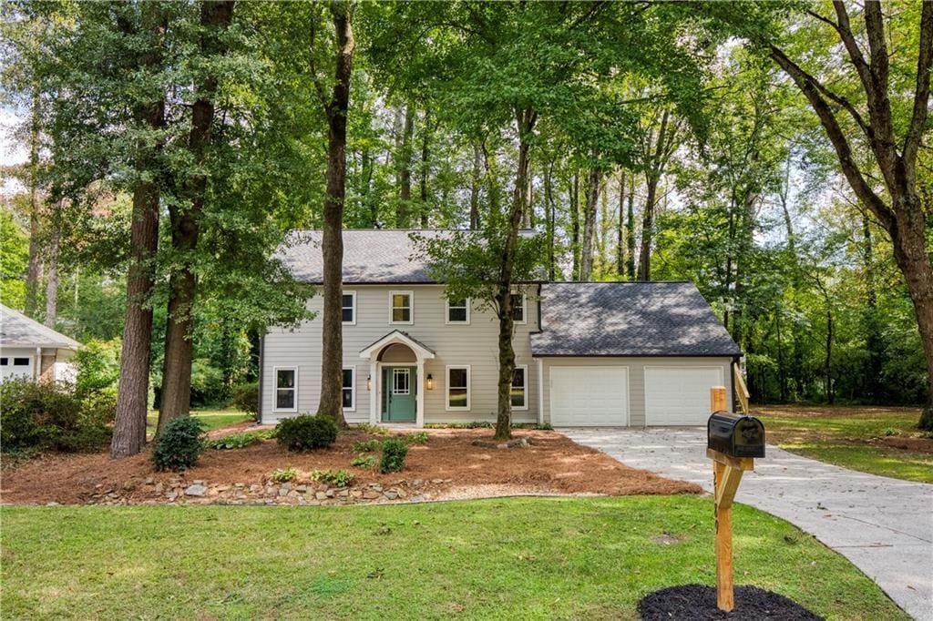 colonial house featuring a garage and a front yard