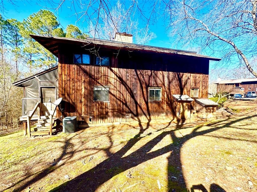 back of property featuring a sunroom and central air condition unit