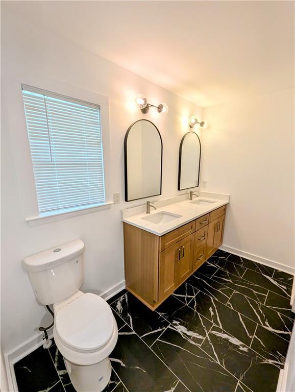 4430 Locksley Rd, Tucker, GA 30084 - bathroom with double vanity, marble finish floor, toilet, and a sink