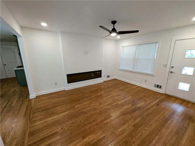 4430 Locksley Rd, Tucker, GA 30084 - unfurnished living room with visible vents, a ceiling fan, wood finished floors, a glass covered fireplace, and recessed lighting