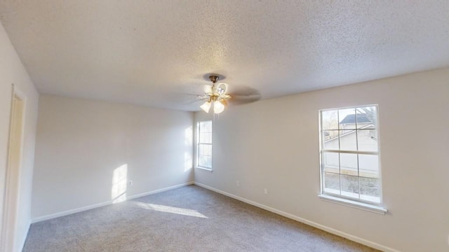 carpeted empty room with a textured ceiling and ceiling fan