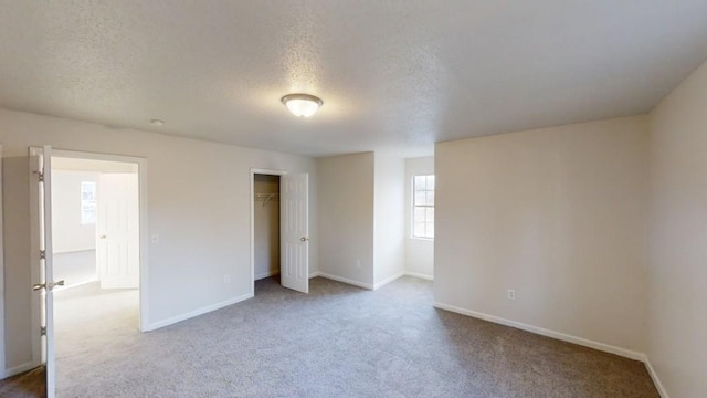 unfurnished bedroom with carpet flooring, a textured ceiling, and a closet