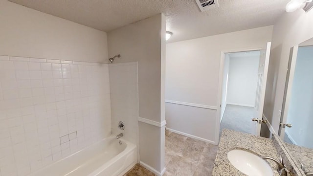 bathroom with vanity, bathtub / shower combination, and a textured ceiling