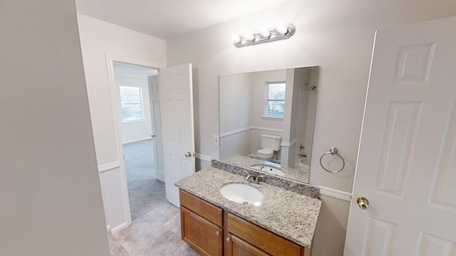 bathroom featuring vanity, toilet, and a healthy amount of sunlight