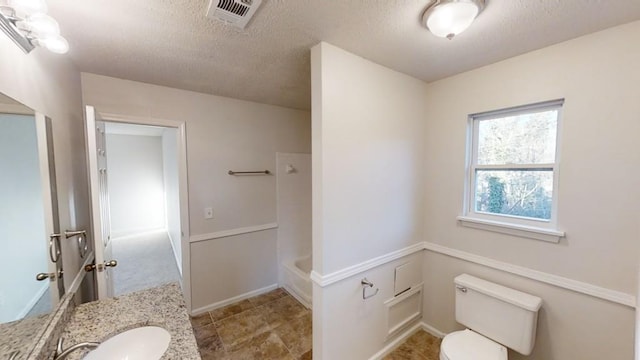 bathroom featuring vanity, toilet, and a textured ceiling