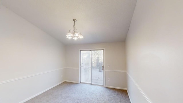 empty room featuring carpet flooring and a notable chandelier