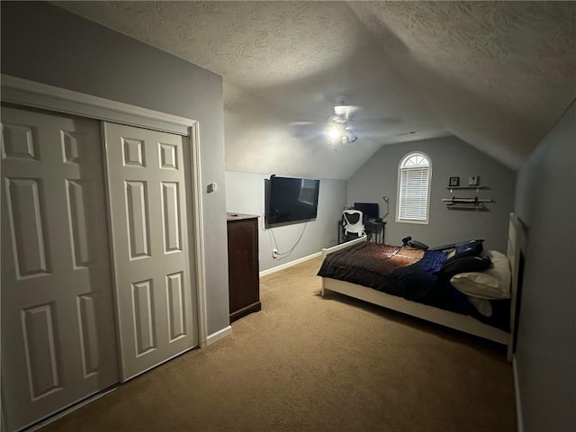 carpeted bedroom with a textured ceiling, ceiling fan, a closet, and lofted ceiling