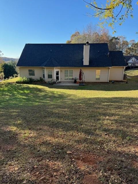 rear view of property featuring a yard and a patio