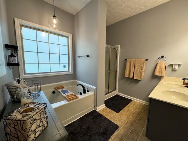 bathroom featuring tile patterned flooring, vanity, a textured ceiling, and independent shower and bath