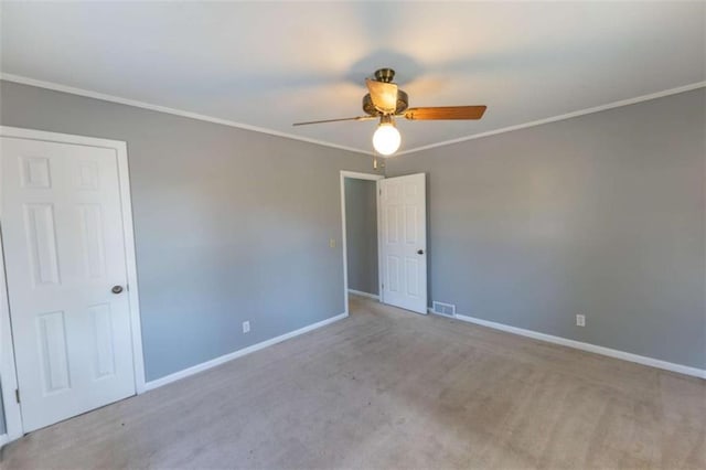 carpeted spare room featuring ornamental molding and ceiling fan