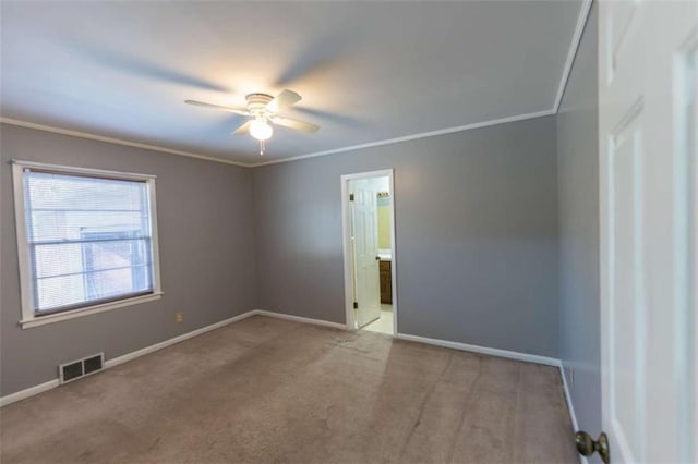 carpeted spare room featuring crown molding and ceiling fan