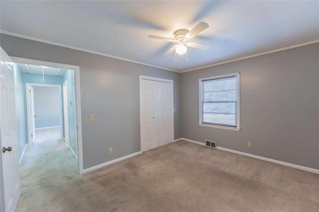 unfurnished bedroom featuring light carpet, crown molding, a closet, and ceiling fan