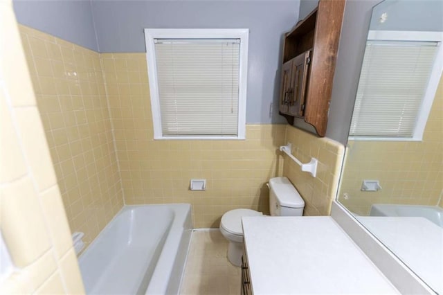 bathroom featuring tile walls, a tub to relax in, vanity, toilet, and tile patterned floors